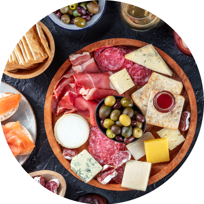 plateau de charcuterie et fromage et accompagnement posé sur une ardoise grise